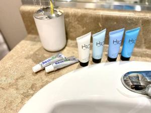 un fregadero con cepillos de dientes y pasta de dientes en un mostrador en NEW! Luxury Apt, 5 min from Mall, Airport, & Dine!, en McAllen