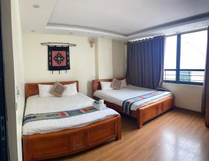 1 dormitorio con 2 camas y ventana en TUONG MAI HOTEL, en Sa Pa