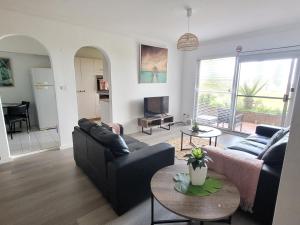 a living room with a couch and a table at Reef Resort Apartments in Mona Vale