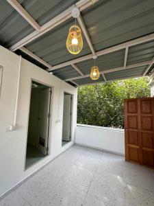 an empty patio with a ceiling and a chandelier at Blessings Home & Café in Haad Pleayleam