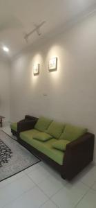 a couch in a living room with two pictures on the wall at TEJAH HOMESTAY in Johor Bahru