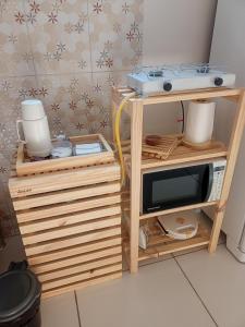 a small kitchen with a microwave and a table with a microwave at Aconchego da Kika in Caruaru