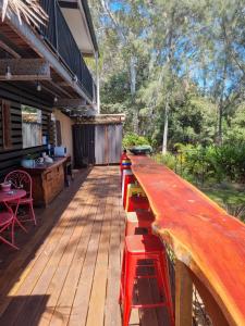 una barra de madera con taburetes rojos en una cubierta en Birdsong Retreat - A BnB on Lamb Island, 