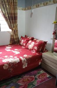 a bedroom with a red bed and a window at Homestay ALHAQIM in Pontian Kecil