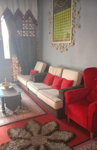 a living room with a couch and a red chair at Homestay ALHAQIM in Pontian Kecil