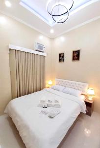 - une chambre avec un grand lit blanc et une lucarne dans l'établissement Lemoons Apartelle, à Tagum