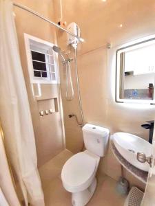 Baño pequeño con aseo y lavamanos en Lemoons Apartelle, en Tagum