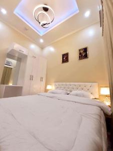 a bedroom with a large white bed with a skylight at Lemoons Apartelle in Tagum