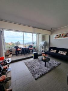 sala de estar con sofá y mesa en Arriendo vacaciones reñaca, en Viña del Mar