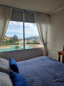 a bedroom with a bed and a large window at Arriendo vacaciones reñaca in Viña del Mar