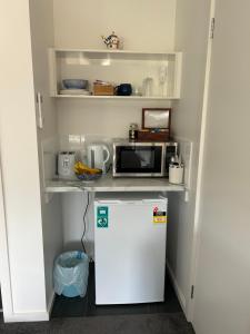 a small kitchen with a refrigerator and a microwave at WhaleEscape Portland in Portland
