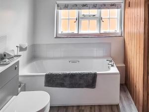 baño blanco con bañera y aseo en Hive Mews en Abingdon