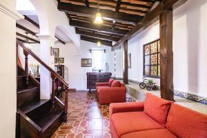 a living room with two red couches and a staircase at Villa Vegent-All equipped Retreat in Antigua Guatemala