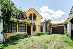 a yellow house with a gate and a yard at Villa Vegent-All equipped Retreat in Antigua Guatemala
