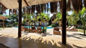 ein Resort mit einem Pool, Stühlen und Palmen in der Unterkunft Kites Mancora in Máncora