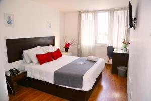 a bedroom with a large bed with red pillows at Hoteles Riviera Ejecutivo in Arequipa