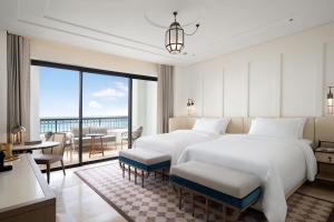 フニデクにあるThe St. Regis La Bahia Blanca Resort - Tamuda Bayのベッド2台とバルコニーが備わるホテルルームです。