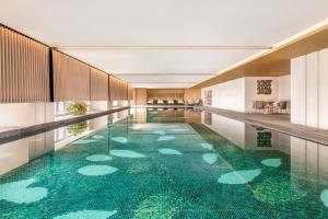 a swimming pool with a green floor in a building at The Westin Wuhan Hanyang in Wuhan