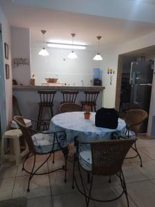 een keuken met een tafel en stoelen en een keuken met een koelkast bij Cabo Frio- Casa pé na areia - Suíte vista mar- Garagem coberta privativa 2 vagas in Cabo Frio