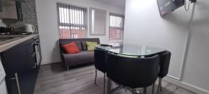 una cucina con tavolo, 2 sedie e un divano di Cosy one bedroom Apartment a Liverpool