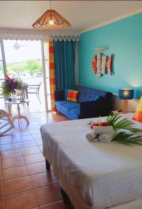 a bedroom with a large bed and a living room at TI OASIS vue Mer dans village Pierre & Vacances in Sainte-Luce