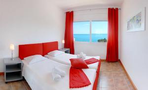 a bedroom with two beds and a window with the ocean at Glyfa Corfu Apartments in Barbati