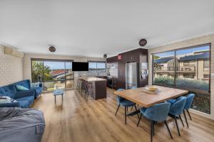 a kitchen and living room with a table and chairs at Capri Apartments in Merimbula