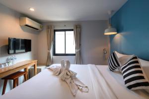 a hotel room with a white bed and a window at Tiya House Rooms & Cafe in Krabi