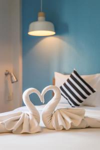 two white swans forming a heart on a bed at Tiya House Rooms & Cafe in Krabi town