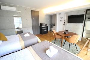 a bedroom with two beds and a table and a kitchen at TAKETO STAY OSAKAJO 9F - Vacation STAY 09349v in Osaka