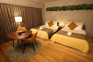 a hotel room with two beds and a table and a table at TAKETO STAY OSAKAJO 9F - Vacation STAY 09349v in Osaka
