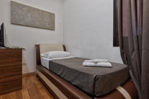 a bedroom with a bed with towels on it at Hotel Trieste in Mestre
