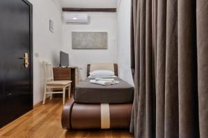 una camera con letto, sedia e tende di Hotel Trieste a Mestre