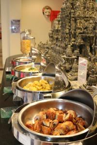 a buffet with several pans of food on a table at Swiss-Belinn Malang in Malang