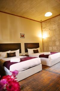 two beds in a hotel room with two beds at Hoteles Riviera Colonial in Arequipa