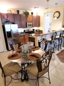 una cucina con tavolo, alcune sedie e frigorifero di Executive 3 Bedroom Villa at Universal a Orlando