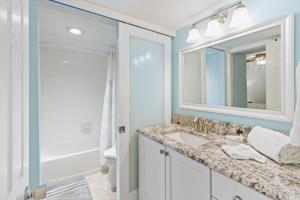 a bathroom with a sink and a mirror and a shower at South Seas Beach Villa 2412 condo in Captiva