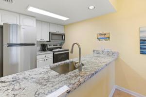 a kitchen with a sink and a refrigerator at South Seas Beach Villa 2412 condo in Captiva