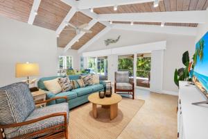 a living room with a blue couch and a table at Wait N' Sea- Previously Millertime home in Captiva