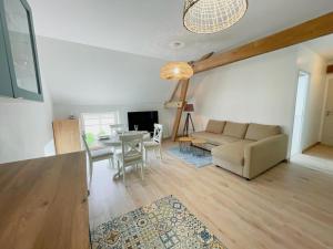 a living room with a couch and a table at Gîte à Luzillé avec jardin privé et climatisation - FR-1-381-532 in Luzillé