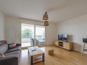 a living room with a couch and a tv and a table at Appartement Calme avec Grande Terrasse, Aytré, Proche Lac, 2 Pers. - FR-1-535-49 in Aytré +5 photos