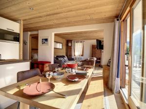 a dining room and living room with a wooden table at Appartement chaleureux Rénové Grand balcon Vue montagne - FR-1-688-67 in Méribel