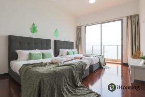 a bedroom with two beds and a large window at Silverscape Deluxe Melaka by I Housing in Melaka
