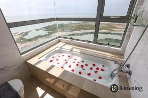 a bath tub with hearts in it in front of a window at Silverscape Deluxe Melaka by I Housing in Melaka
