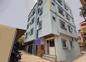 een groot wit gebouw met blauwe ramen aan een straat bij SPOT ON Shree Gajanan in Aurangabad
