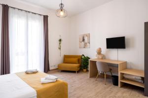 um quarto de hotel com uma cama, uma secretária e uma cadeira em Sister's Suites Rooms em Palermo