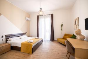 um quarto com uma cama, uma cadeira e um sofá em Sister's Suites Rooms em Palermo