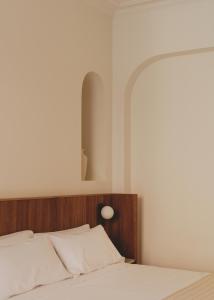 a bedroom with a bed with a wooden headboard at Casa Llimona Hotel Boutique in Barcelona