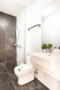 uma casa de banho branca com um WC e um lavatório em 9min drive to City Highfloor Aprmt City Skyline View Water Purifier em George Town