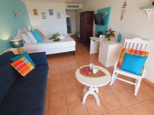 a living room with a couch and a table and chairs at TI OASIS vue Mer dans village Pierre & Vacances in Sainte-Luce